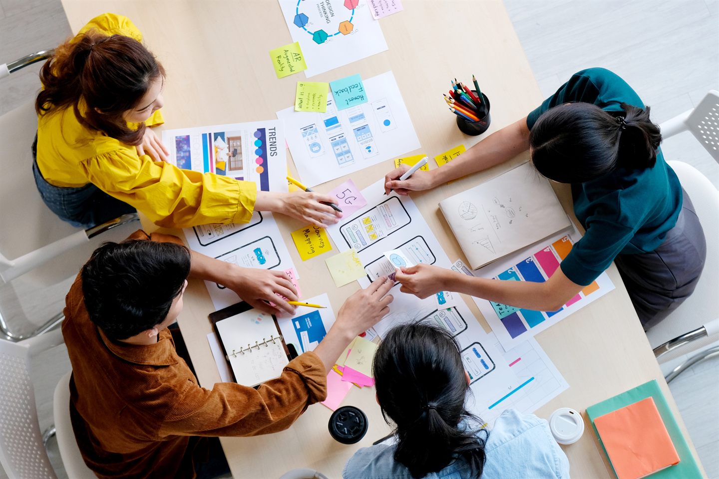 A product team collaborating over materials spread across a work table